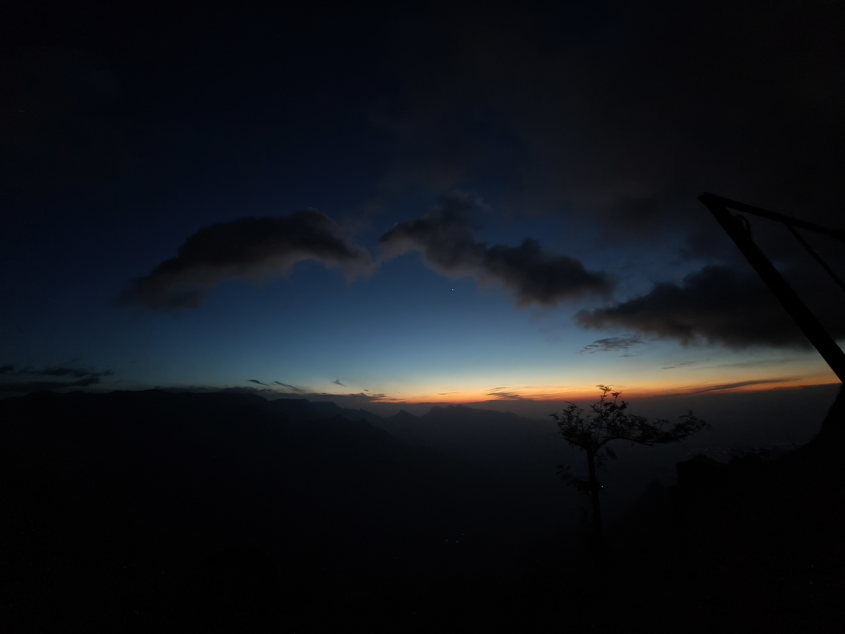 Kolukkumalai dramatic sunrise with glowing red sky and mountain valley view